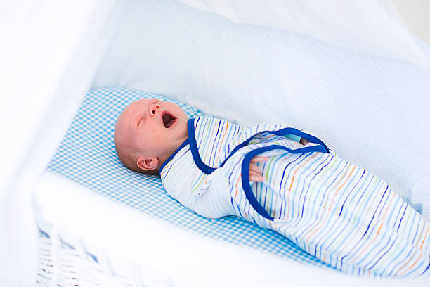 istock Little swaddled baby in white bed 485715892