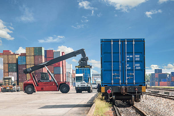 forklift handling container box loading to freight train stock photo
