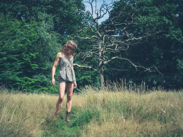 istock Young woman standing in meadow 485727694