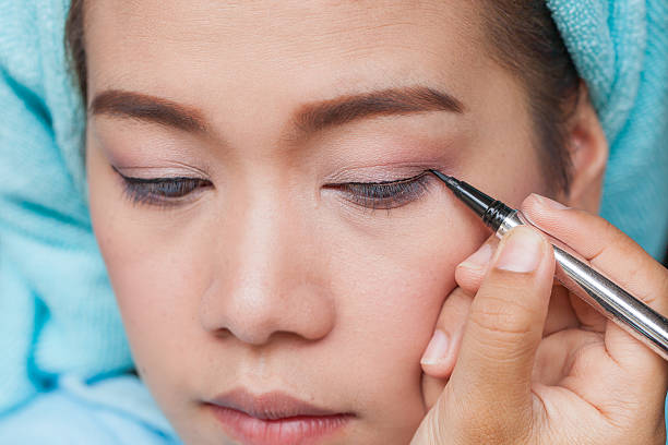 istock Closeup asian woman applying eyeliner on eye 485728640