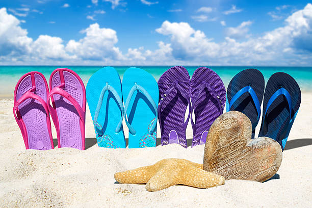 istock Flip flops and wooden heart on the beach 485728966