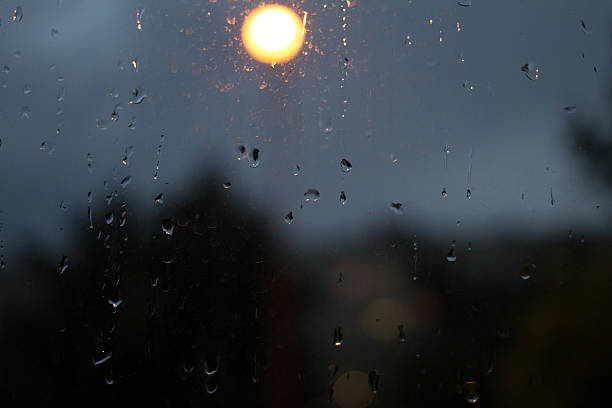 istock Drops of rain on window with abstract lights 485729078