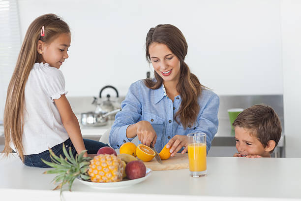 istock Woman cutting an orange for her children 485730863