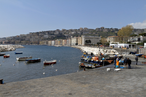 This view around the Bay / Gulf of Naples in Italy includes fishermen standing with their morning's catch on the Rotonda Diaz. The view is along the coast looking south-west.