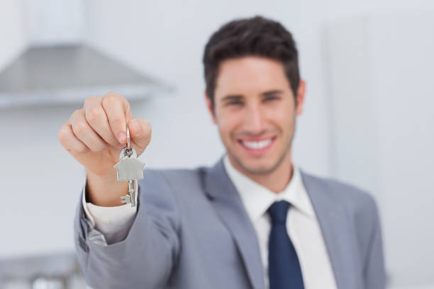 istock Real estate agent presenting house key 485734451