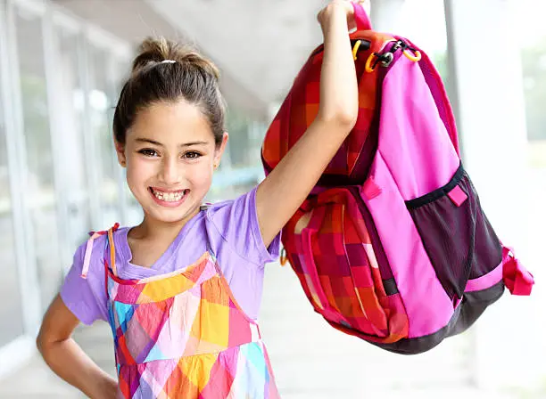 Smiling girl holding backpack