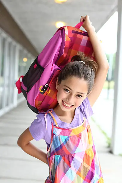Smiling student holding backpack