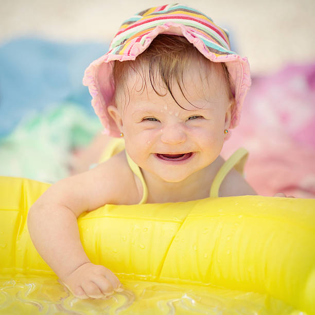 bébé avec le syndrome de down fille jouant dans la piscine - seulement des bébés photos photos et images de collection