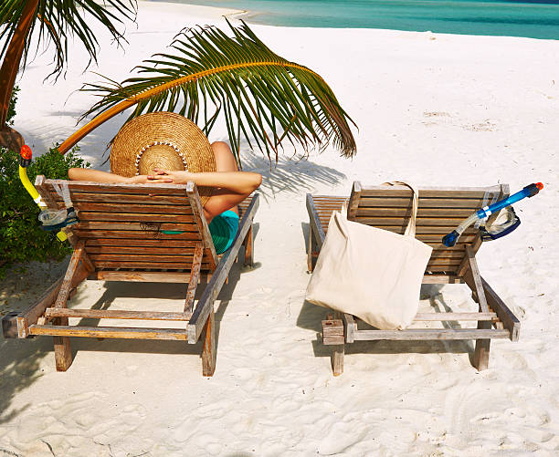 istock Woman at beach with chaise-lounges 485735835