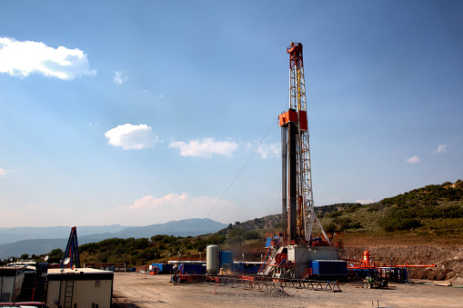 Drill rig in a remote location in the mountains. Rig is performing a fracking operation to liberate trapped crude oil and natural gas into the pipeline to a refinery.