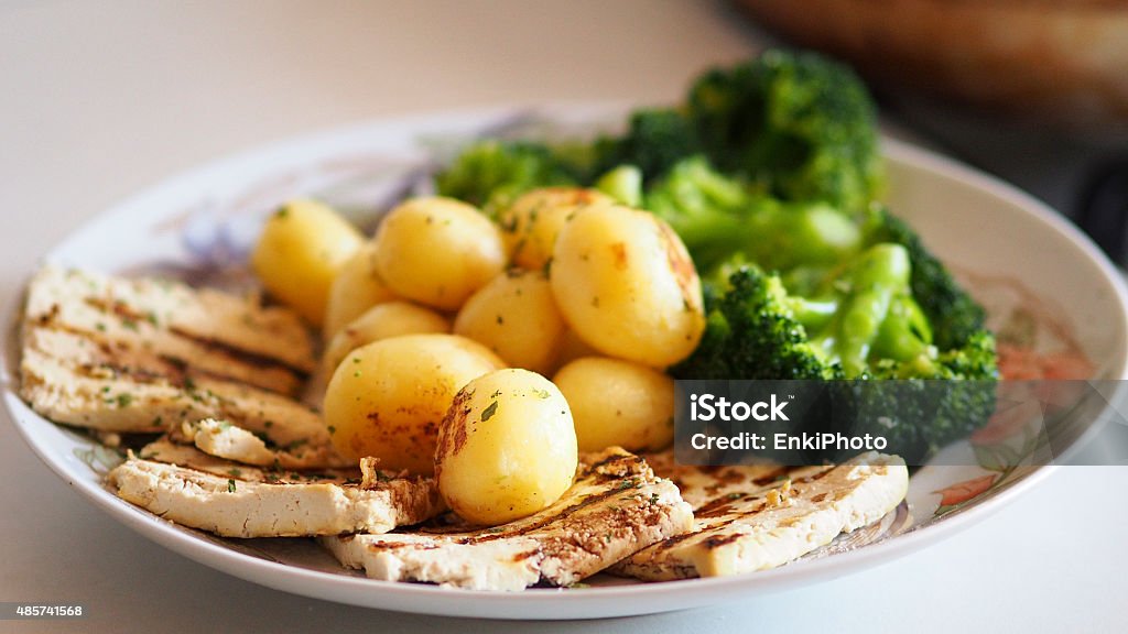 Vegan dish with tofu and vegetables. Grilled soy tofu with potatoes and broccoli. Vegan and healthy food. Broccoli Stock Photo
