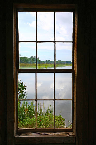 istock Pond seen through an old wooden window 485750734