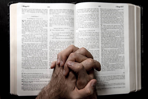 istock man praying over the bible 485751142