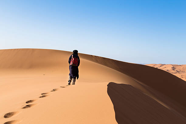 istock One male tuareg climbing a dune in the desert. 485757322