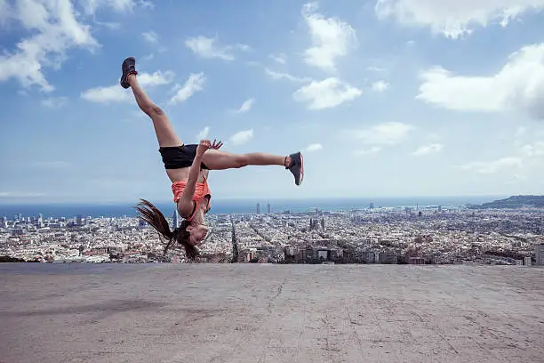 Photo of Young woman practicing parkour in the city of Barcelona