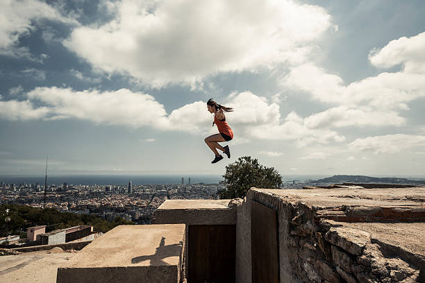 Girl jumping and practicing parkour in the city Urban parkour center athlete stock pictures, royalty-free photos & images