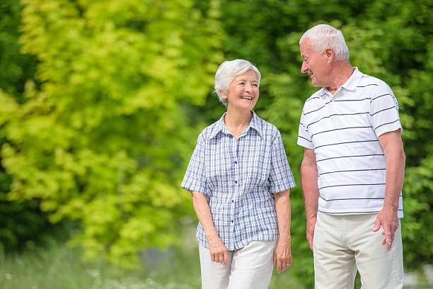istock Senior couple walking in park 485762230