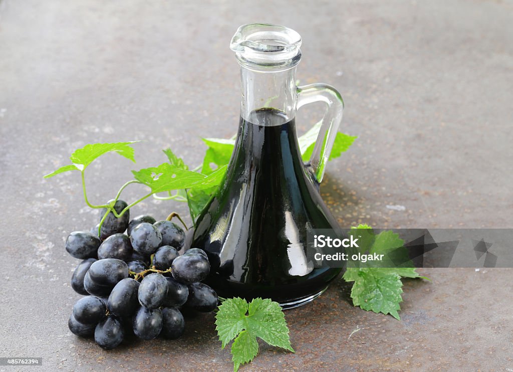 balsamic vinegar in a glass jug with fresh grapes Balsamic Vinegar Stock Photo