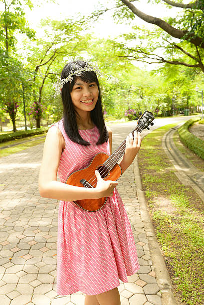 istock Thai young girl with Ukulele in garden 485764906