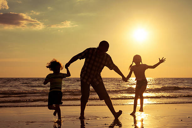 istock Father and children playing on the beach 485765590
