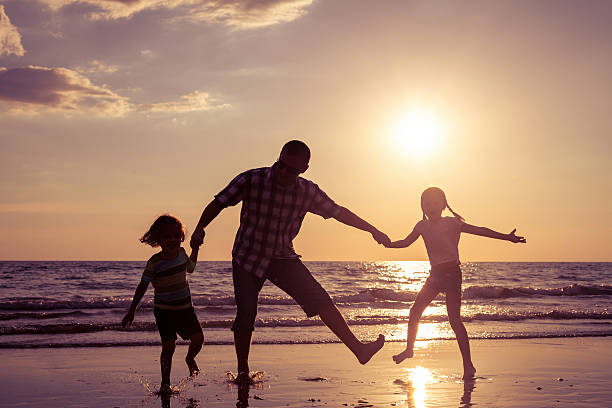 istock Father and children playing on the beach 485765600