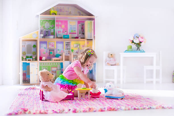 Kids playing with stuffed animals and doll house Little girl playing. Kids with doll house and stuffed animal toys. Children sit on a pink rug in a play room at home or kindergarten. Toddler kid with plush toy and dolls. Birthday party for little child. girl playing with doll stock pictures, royalty-free photos & images
