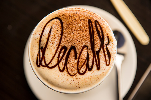 Decaffeinated coffee photographed from above dusted with cocoa 