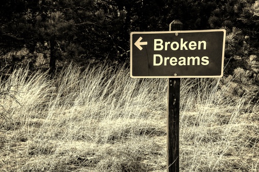 Wooden sign with arrow pointing the way to broken dreams.
