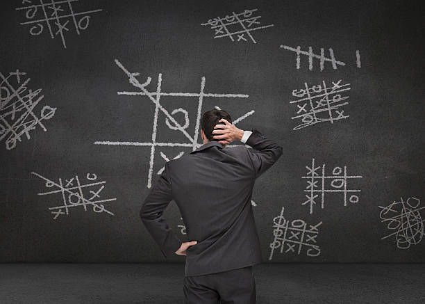 istock Thoughtful businessman looking at Tictac-toe game 485773787