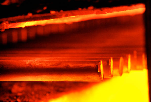 Steel quenching at high temperature in industrial furnace at the workshop of a forge plant. Process of cooling, heat treatmen. Blacksmith and metallurgical industry, steelmaking, hot rolling mill