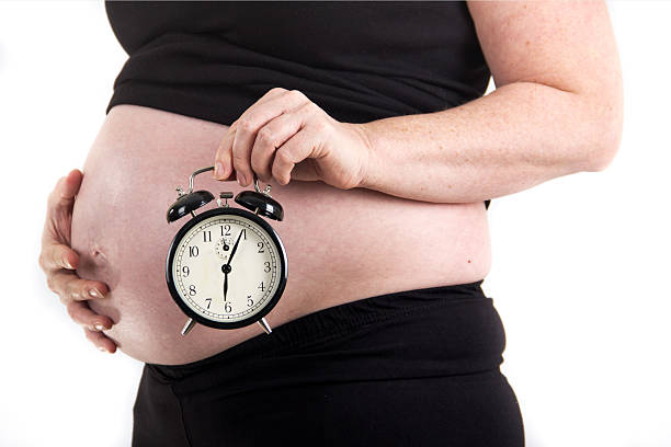 istock pregnant woman alarm clock due time 485775686