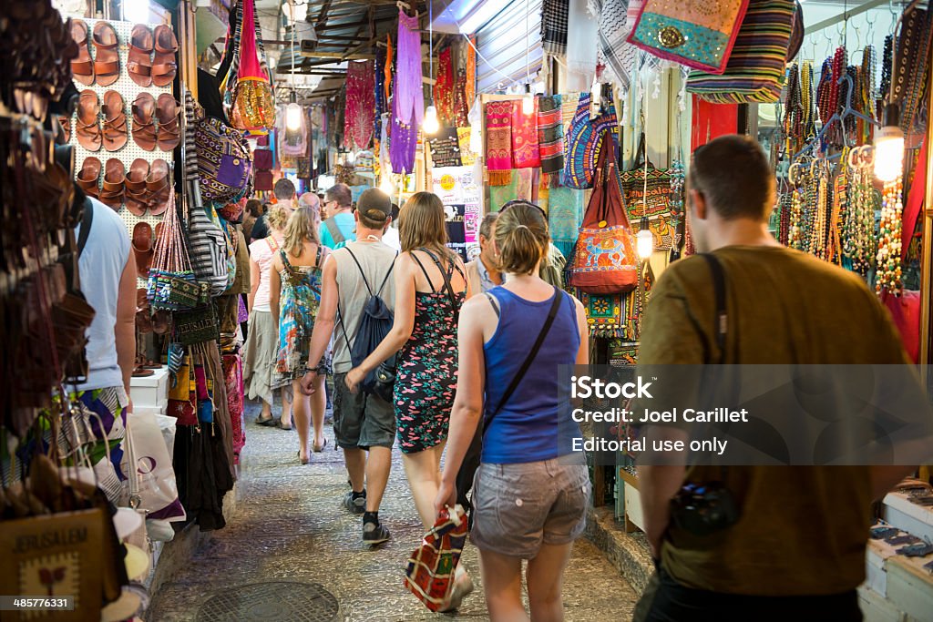 Touring Jerusalem's Old City Jerusalem, Israel - July 25, 2013: A group of young Western men and women navigate a narrow alley of shops in the Muslim Quarter of Jerusalem's Old City Israel Stock Photo