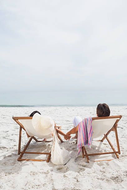 istock Couple looking ocean on their deck chairs 485777705