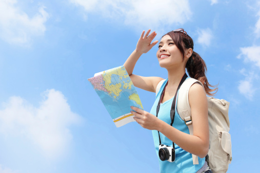 Happy travel woman look map and look copy space with sky background, asian
