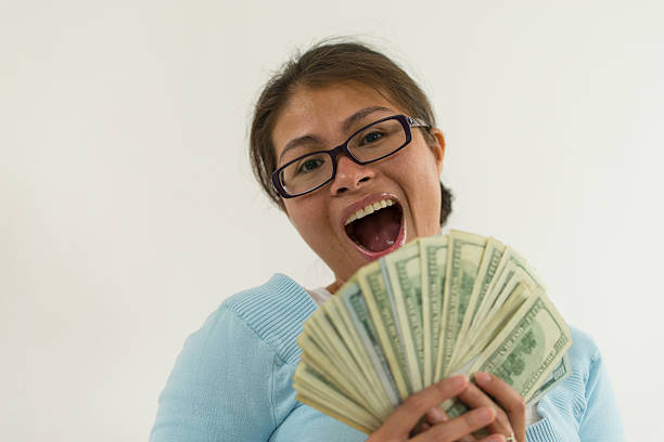 istock Woman holding $5,000 dollars 485779073
