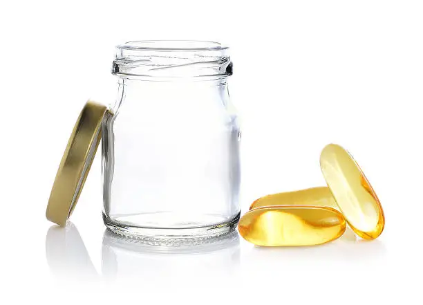 Fishoil pills out of bottle on white background