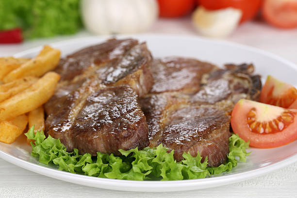 istock Pork chops steaks meal with fries, vegetables and lettuce 485787854