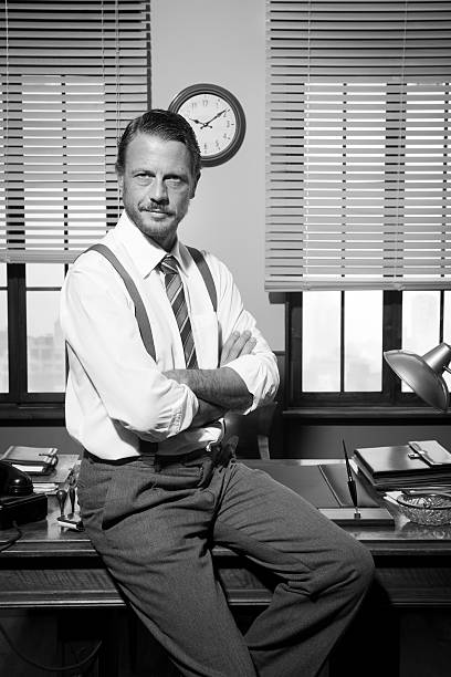 istock Smiling vintage businessman sitting on desk 485795218