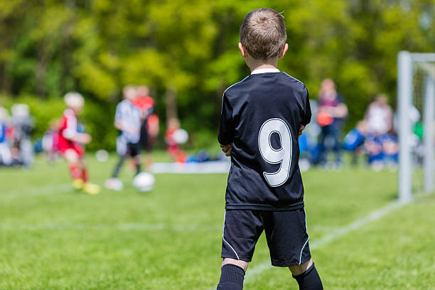 istock Young boy watching a kids soccer match 485796652