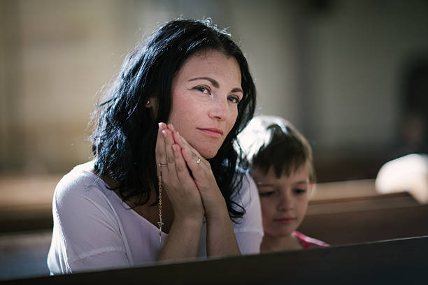 istock Woman with her son praying 485798740