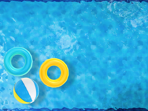 pool top view with swim rings and beach ball