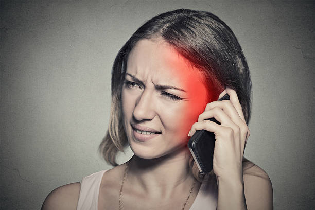 fille heureuse sur le téléphone avec des maux de tête - radiation photos et images de collection