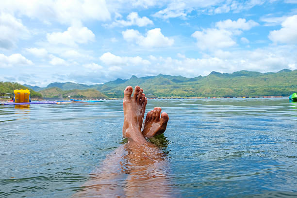 istock Feet and river summer landscape with trees and clouds 485803618