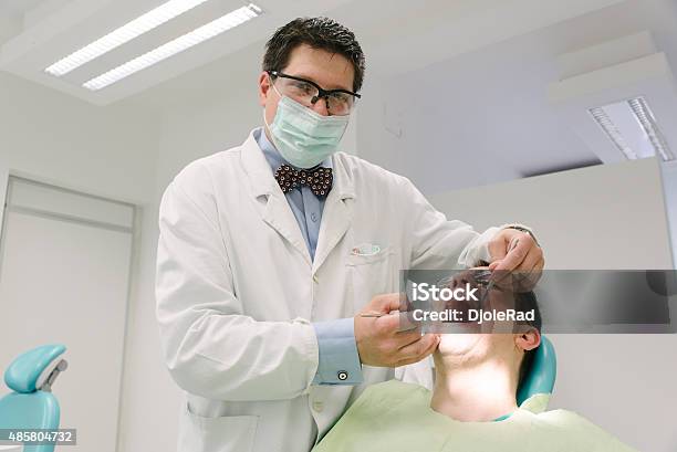 Dentist Examining His Patient Stock Photo - Download Image Now - 2015, Adult, Adults Only