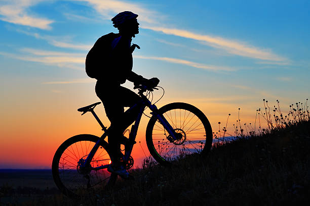 istock Silhouette of a biker and bicycle on sky background. 485805544