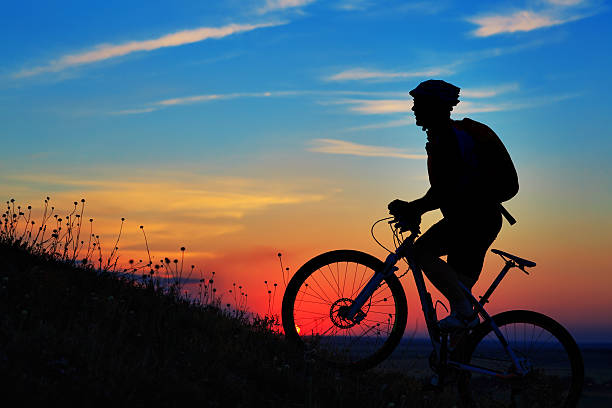istock Silhouette of a biker and bicycle on sky background. 485805972