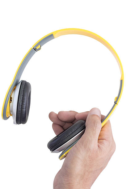 istock right hand holding yellow headphone 485806242