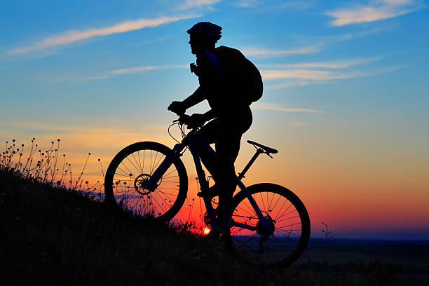 istock Silhouette of a biker and bicycle on sky background. 485806492