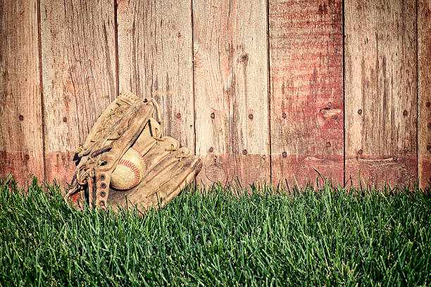 vieux baseball, gant de balle sur pelouse avec barrière en bois - baseball glove baseball baseballs old fashioned photos et images de collection