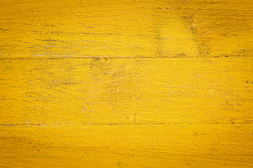 closeup of grunge yellow painted, rough wood background